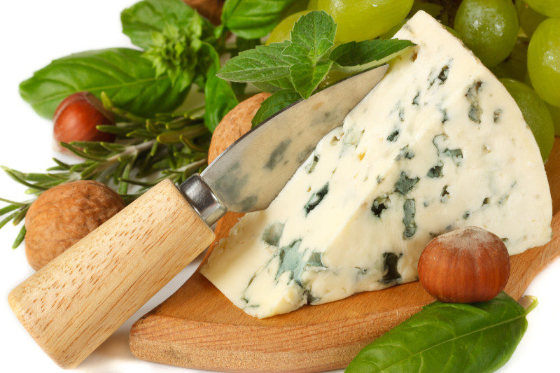 Delicious blue cheese with knife, nuts and spices herbs.